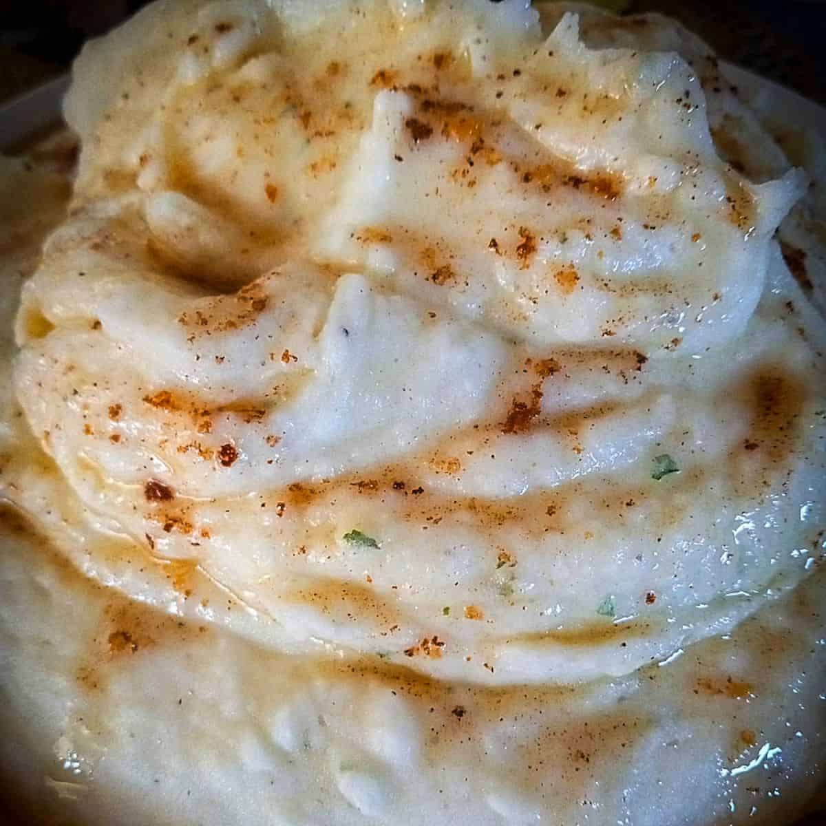 close up of a bowl of mashed potatoes with brown butter
