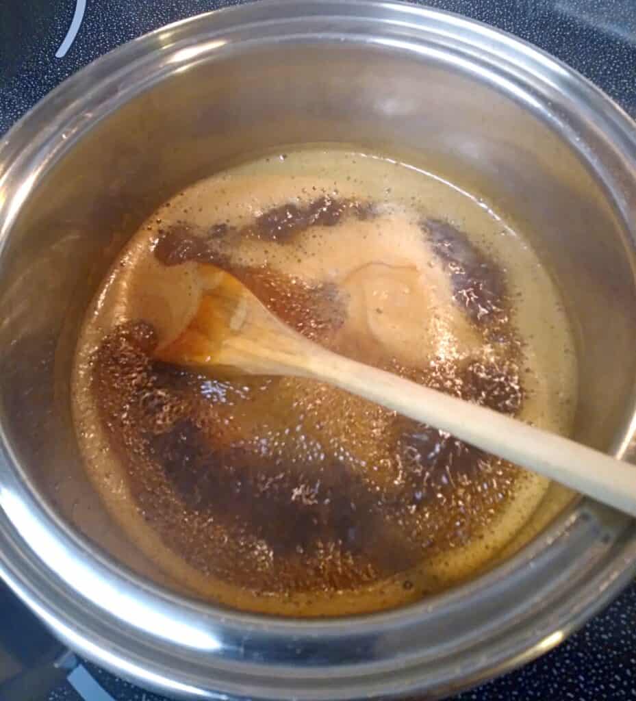 cooking the sugars, water, and molasses in a saucepan.