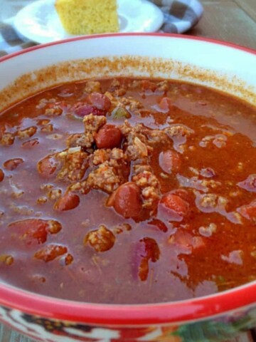 a bowl of Amish chili soup with a piece of cornbread in the background.