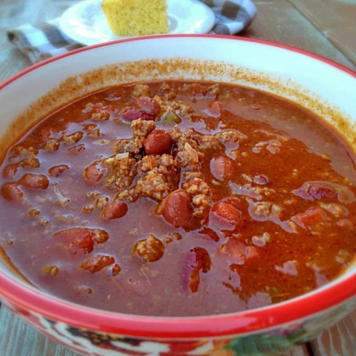 a bowl of Amish chili soup with a piece of cornbread in the background.