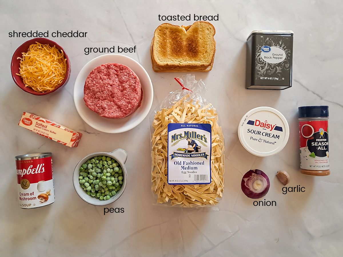 Ingredients: noodles, ground beef, peas, mushroom soup, sour cream, shredded cheese, butter, bread crumbs, onion, garlic, black pepper, seasoned salt.