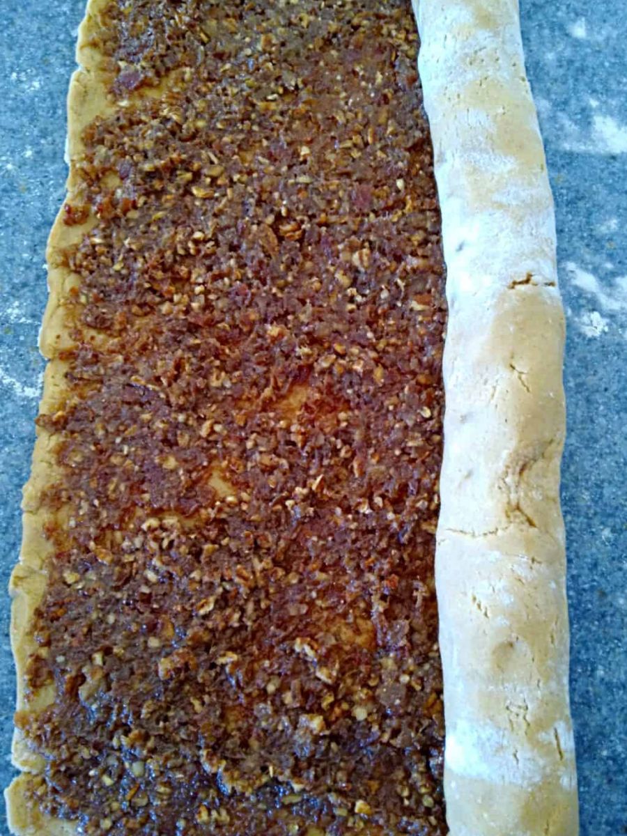 basic cookie dough rolled out with date filling spread on top.