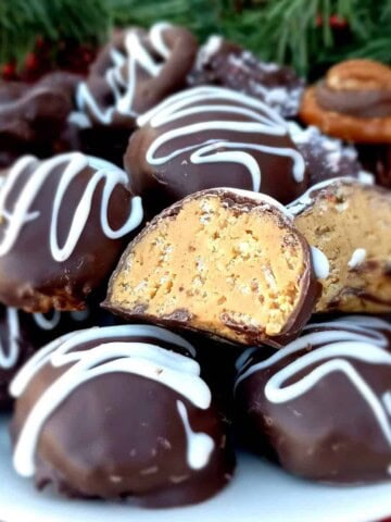 a plate full of chocolate covered peanut butter balls.