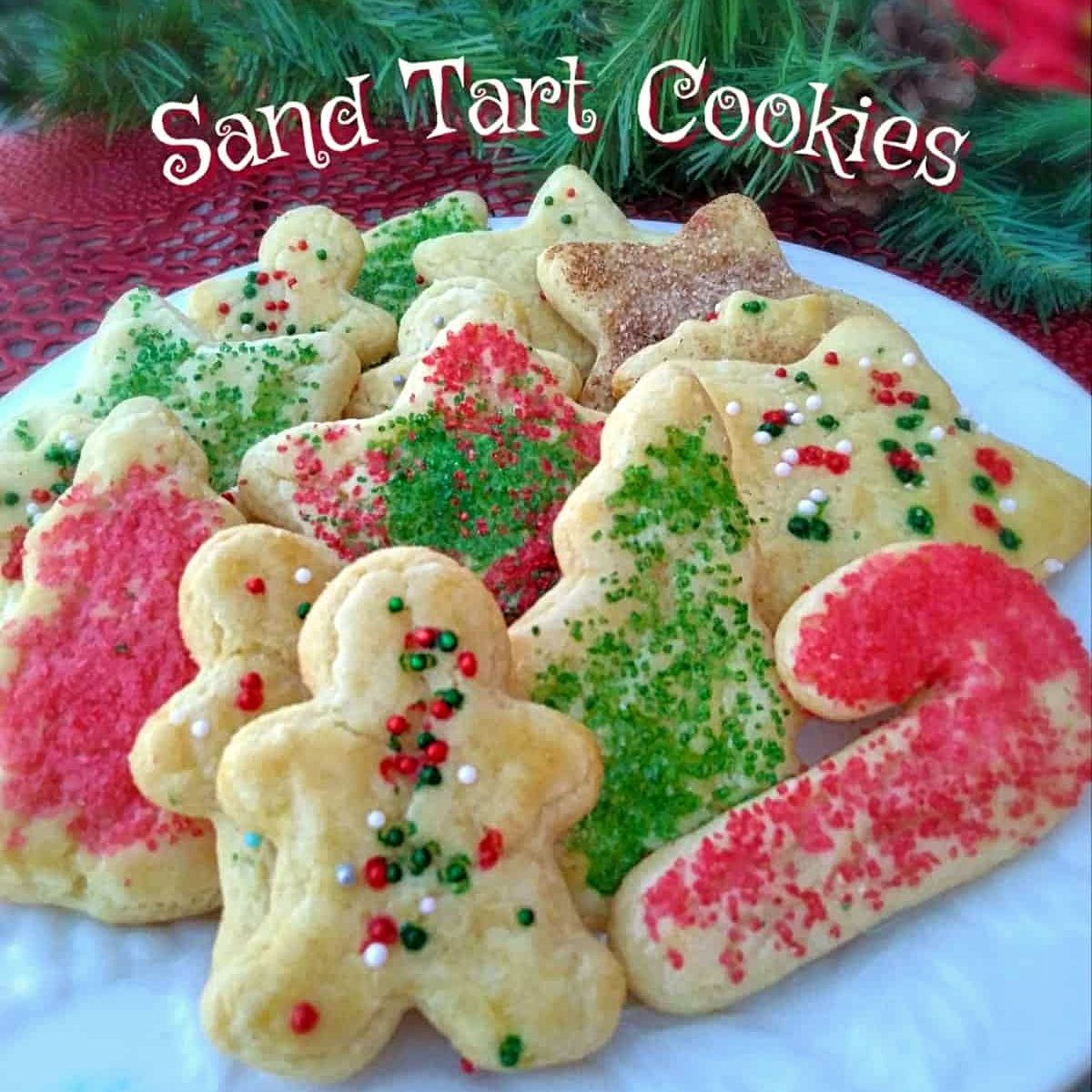 a plate of beautifully sprinkled Christmas sand tart cut-out cookies.