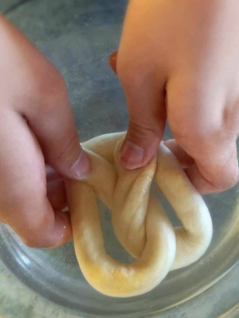 dipping a pretzel into the soda water solution.