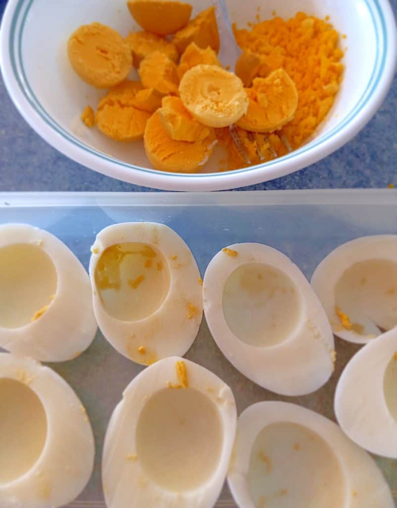 boiled egg yolks in a bowl, egg whites in a container.