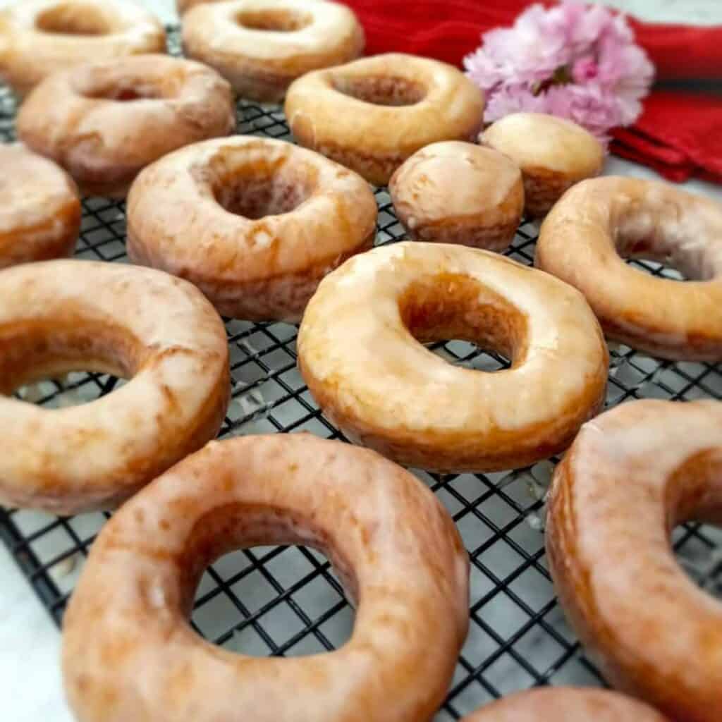 Amish glazed donuts on a wire rack.