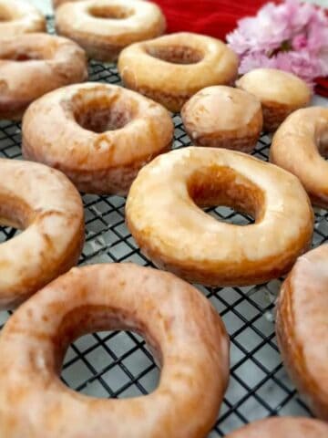 Amish glazed donuts on a wire rack.