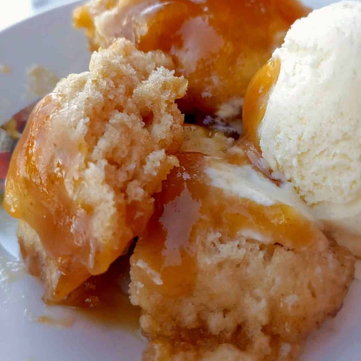 old-fashioned Amish caramel dumplings in a bowl with a scoop of vanilla ice cream.