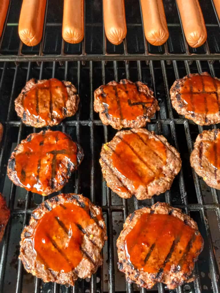 barbecued burgers and hot dogs on the grill