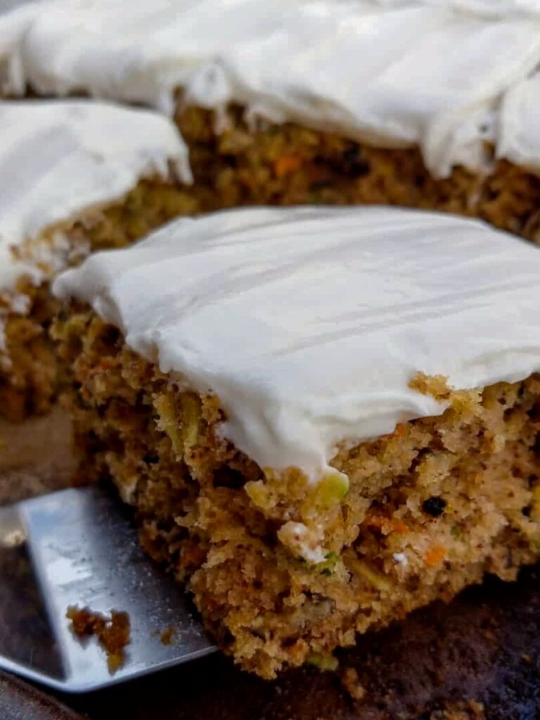a moist zucchini bar with cream cheese frosting on a spatula.