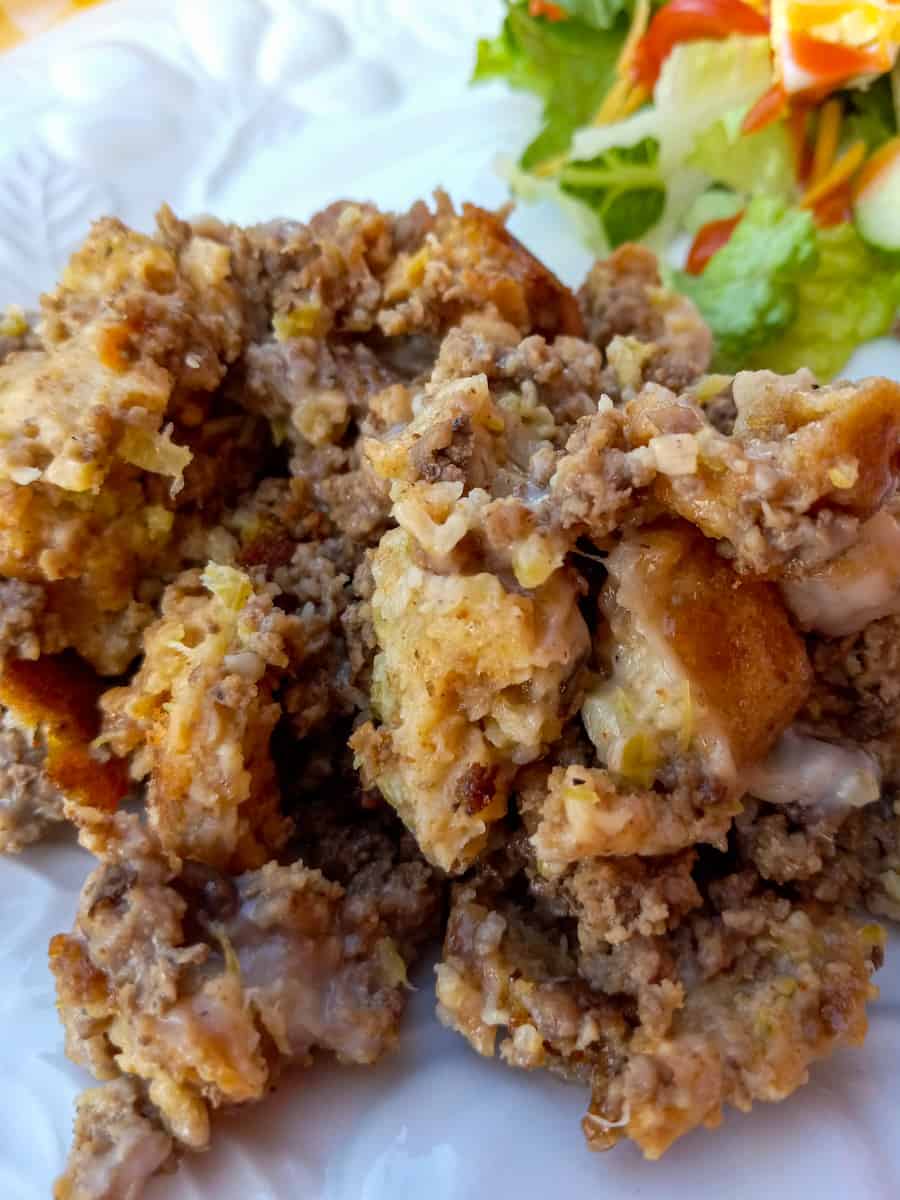 Amish hamburger stuffing on a plate with salad.