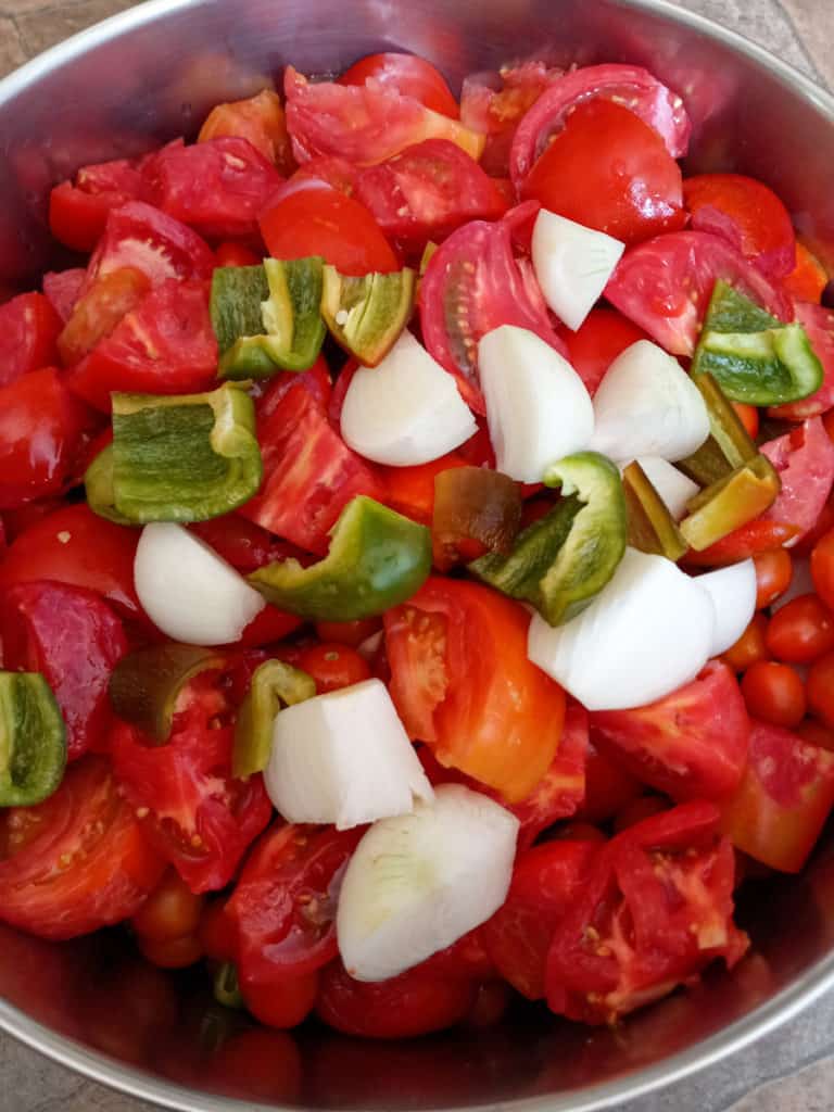 pot of tomatoes, peppers, and onions ready to cook