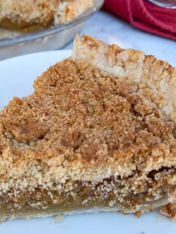 a closer look at a slice of Amish vanilla crumb pie on a plate.