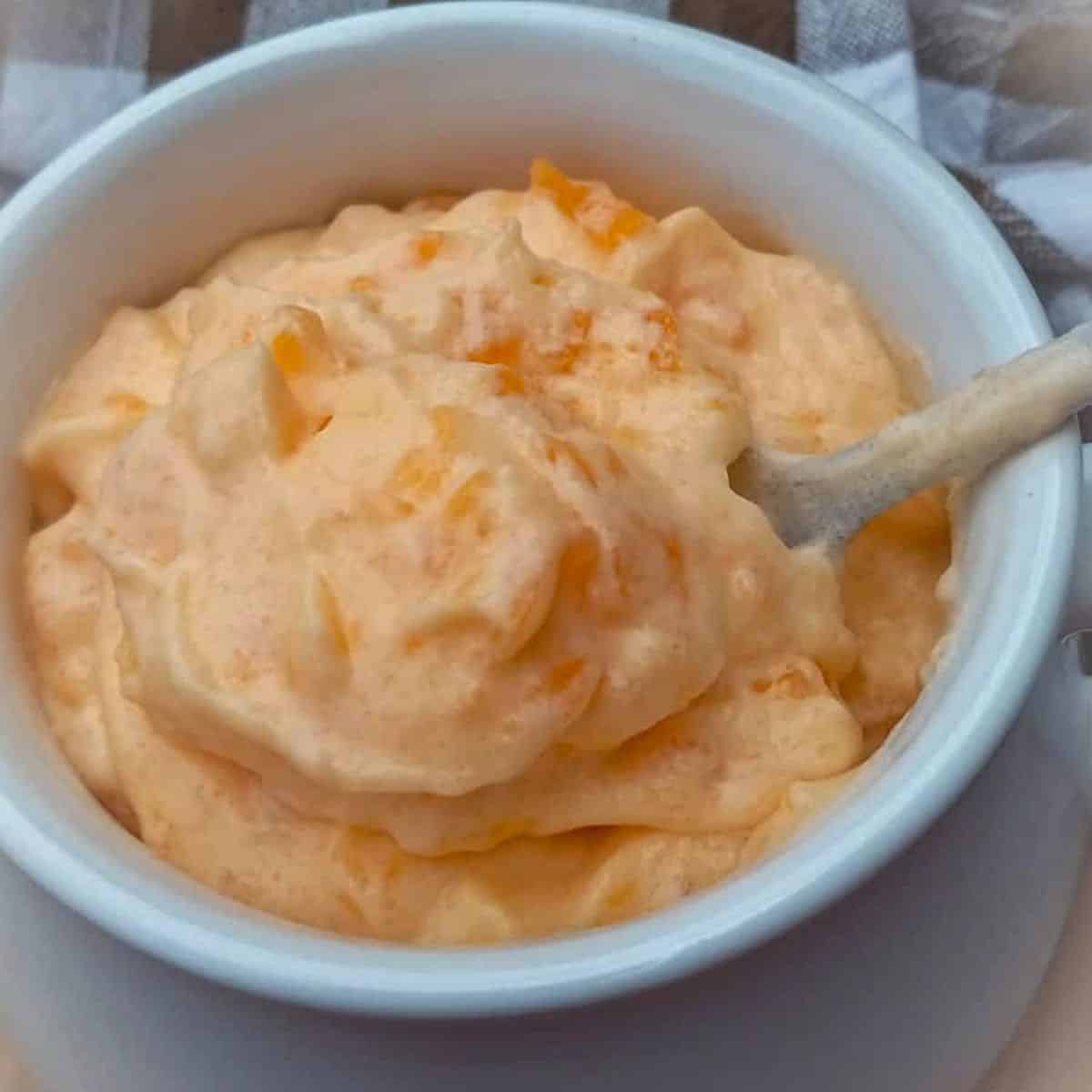 a small crock full of Amish yum yum orange jello salad.