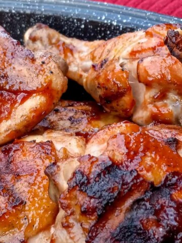 a pan full of grilled Amish BBQ chicken legs and thighs ready to eat.