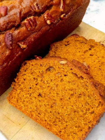 pumpkin bread loaf and slices on a board.