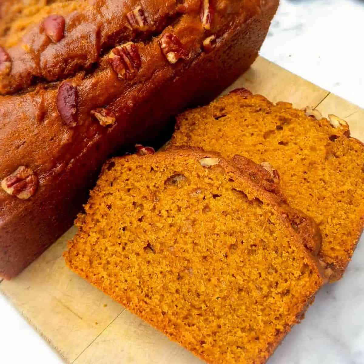 pumpkin bread loaf and slices on a board.