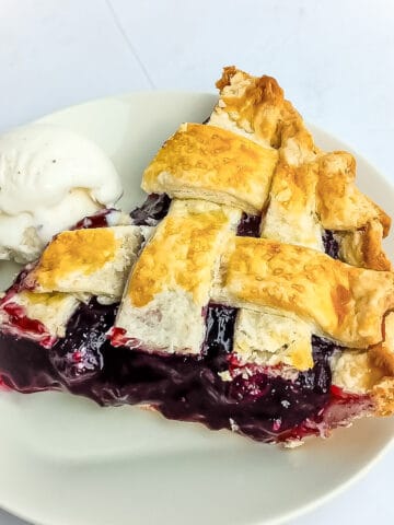 slice of Amish blueberry pie and a scoop of ice cream on a small plate