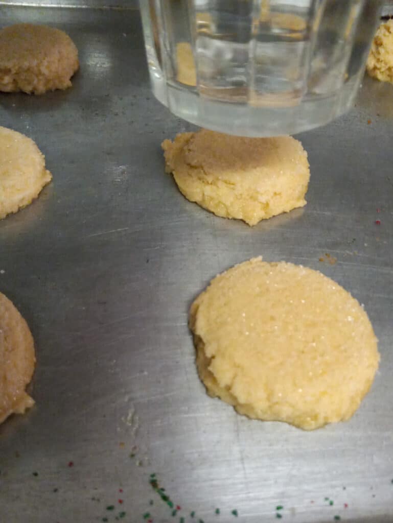 smashed cookie dough balls on baking sheet

