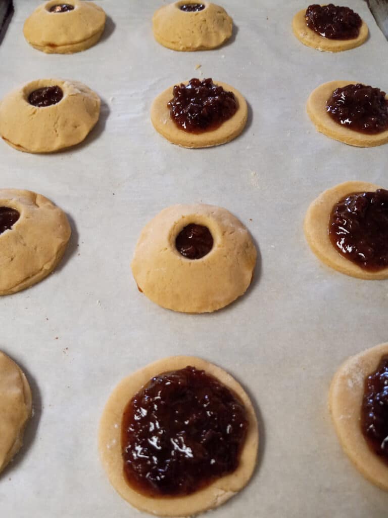 creating raisin-filled cookies on baking sheet
