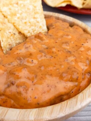 a bowl of cheesy Amish velveeta hamburger chip dip with tortilla chips.