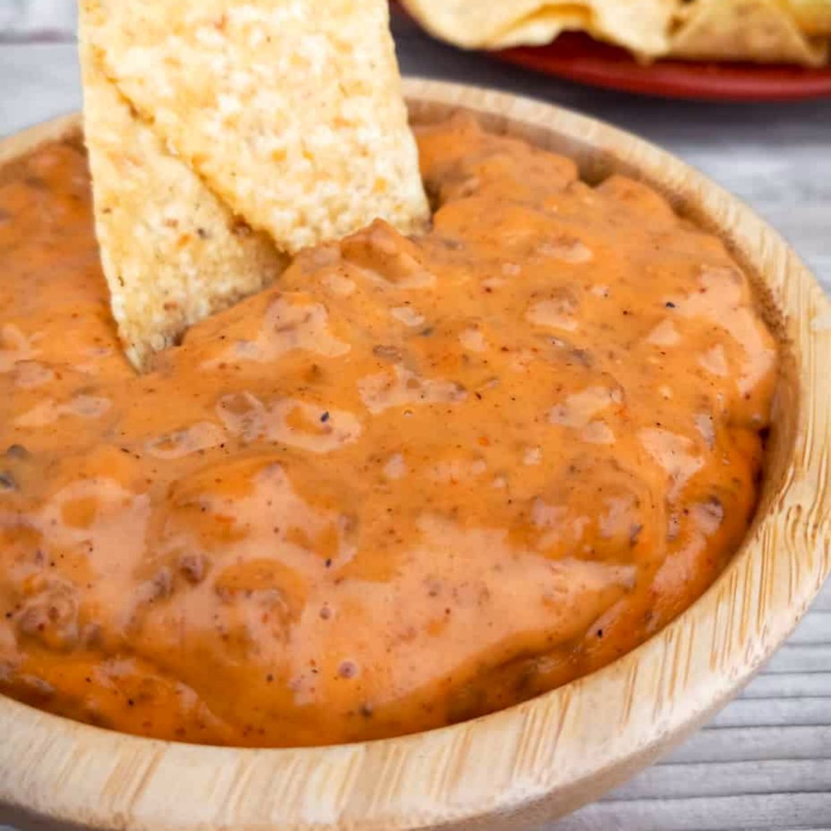 a bowl of cheesy Amish velveeta hamburger chip dip with tortilla chips.
