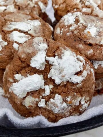a cast iron skillet with a towel and filled with Amish snowtop cookies
