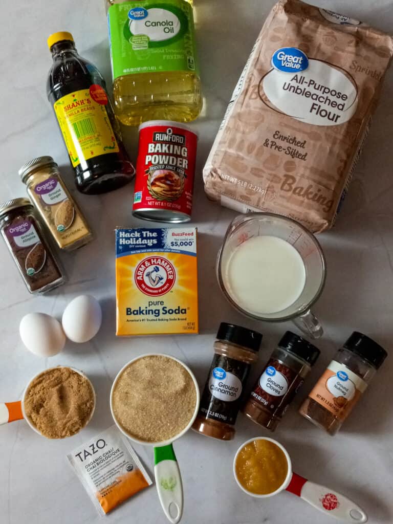 Ingredients - flour, oil, baking powder, soda, milk, sugar, eggs, chai tea bag, applesauce, and spices