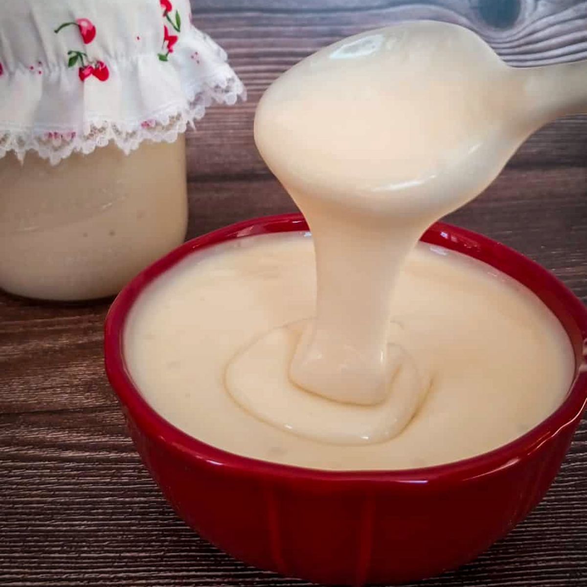 a bowl of Amish cup cheese and we're drizzling some off a spoon to show the consistency.