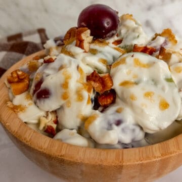 wooden bowl full of creamy grape salad