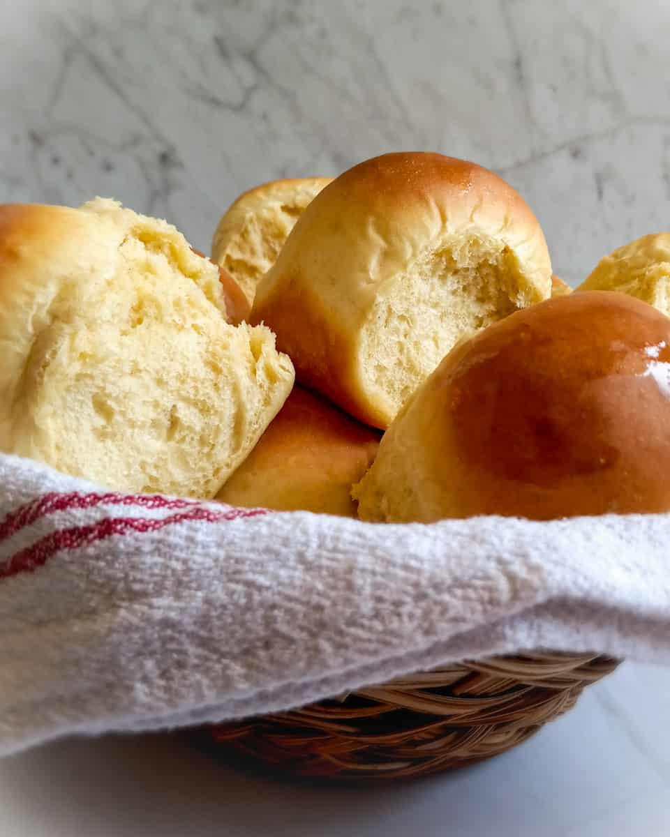 Amish one hour yeast rolls in a basket with towel