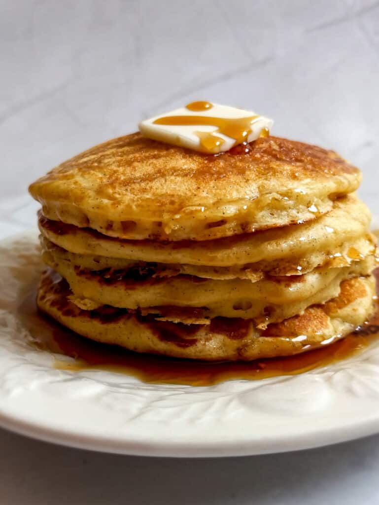 stack of buttermilk pancakes with butter and syrup