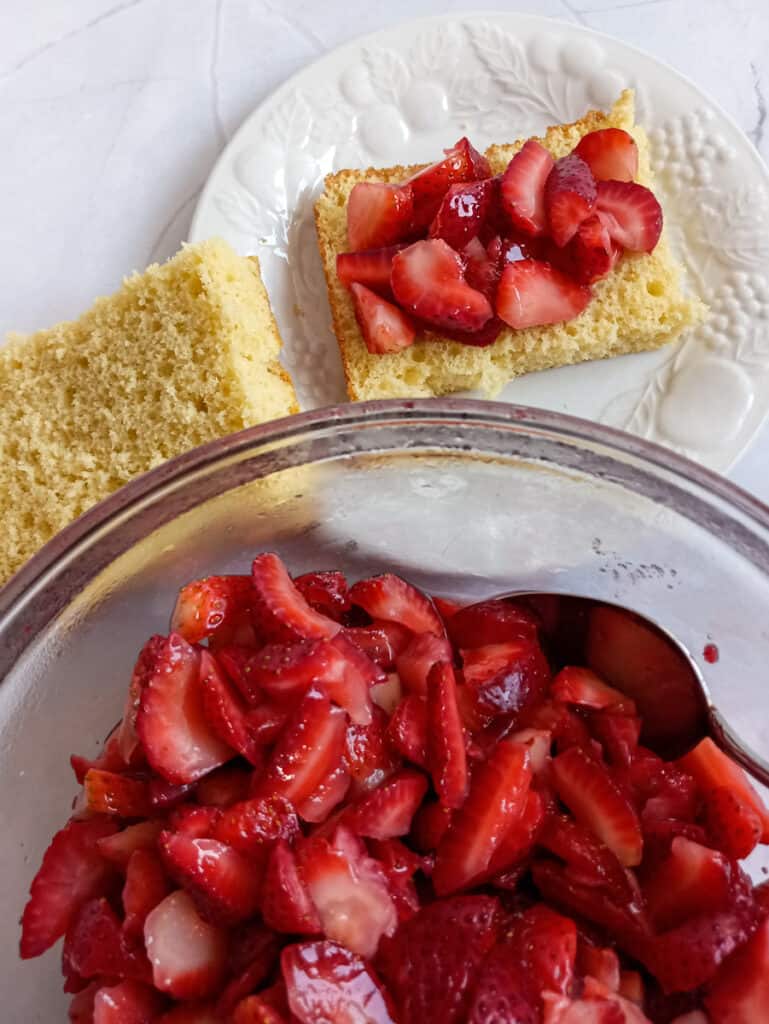 topping a slice of strawberry shortcake with berries