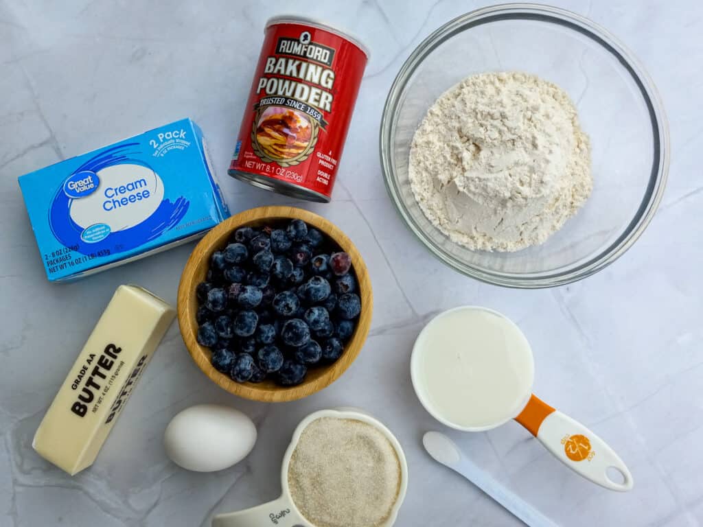 Ingredients - flour, baking powder, sugar, egg, butter, milk, cream cheese, and blueberries