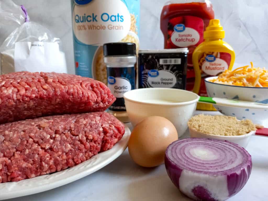 Ingredients: ground beef, onion, egg, oats, milk, salt, pepper, garlic powder, cheese, ketchup, mustard, and brown sugar