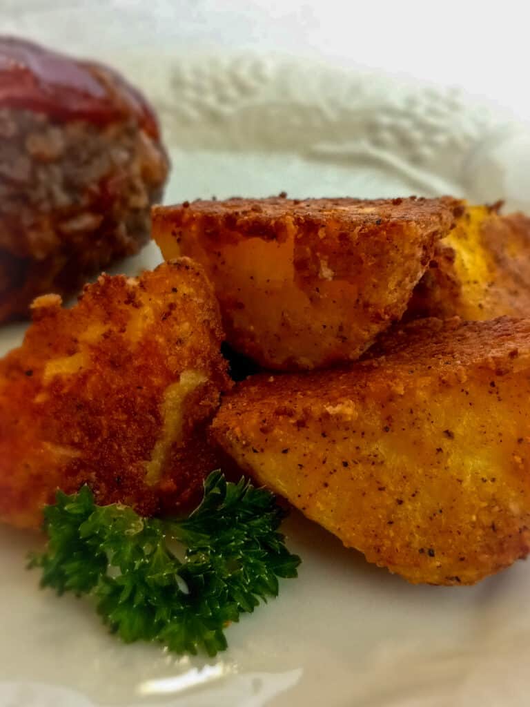 Amish parmesan potatoes on a plate with a mini meatloaf