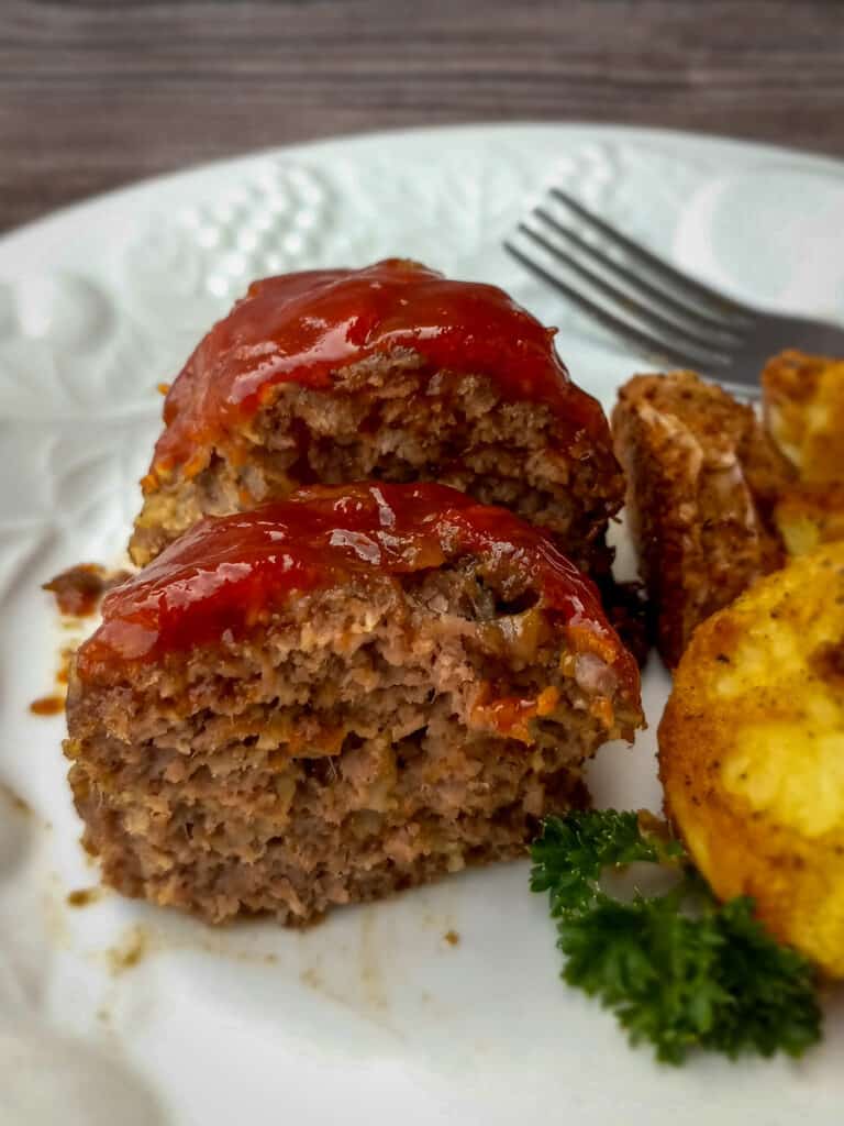little meatloaf cut in half on a plate with potatoes