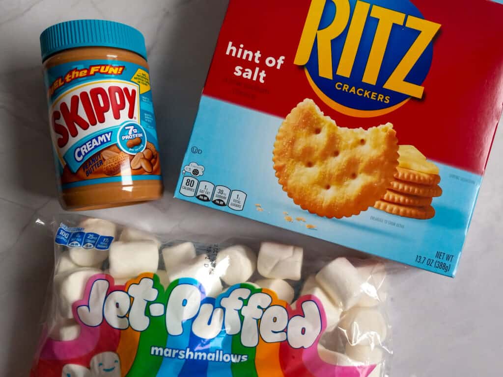 a box of Ritz crackers, bag of marshmallows, and a jar of peanut butter.