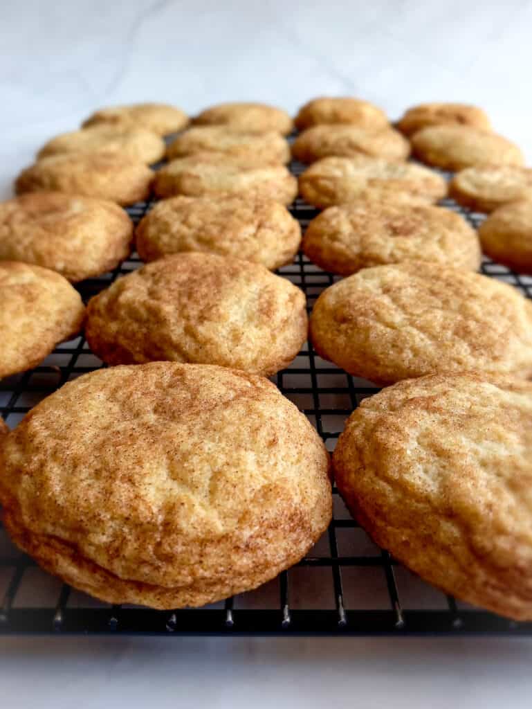 cinnamon and sugar coated snickerdoodle cookies on a cooling rack.