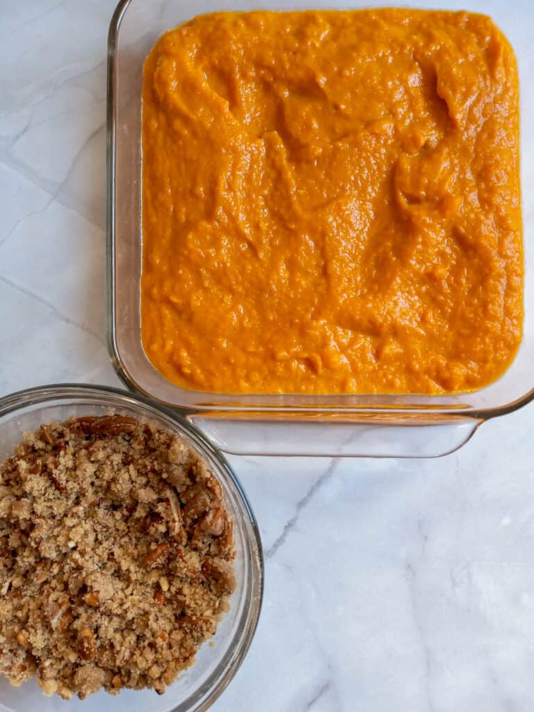 mashed sweet potato mixture in 9" square dish and streusel topping in a bowl.