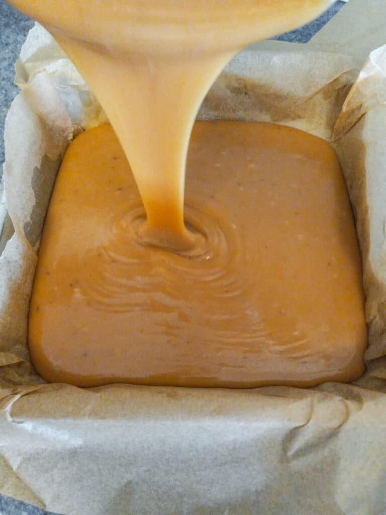 pouring caramel into a 9" pan.