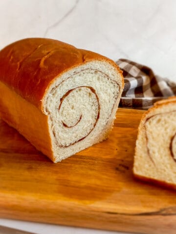 Amish cinnamon swirl loaf on a board with a few slices.