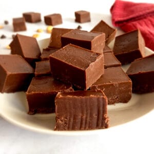 Amish peanut butter chocolate fudge pieces on a plate and scattered around.