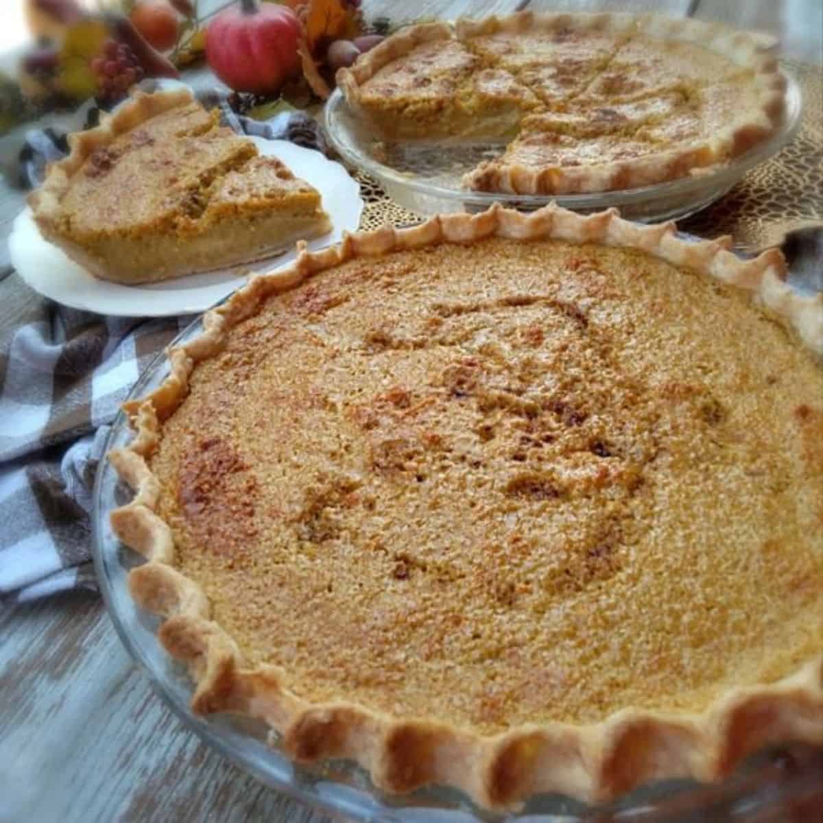 9" Amish pumpkin custard pie, a plate with a slice, and the remaining pie in the background.