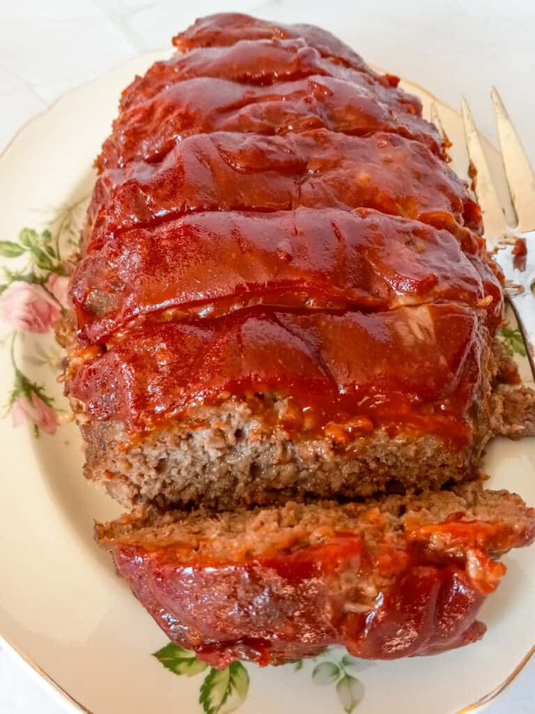 sliced meatloaf on a large serving plate.