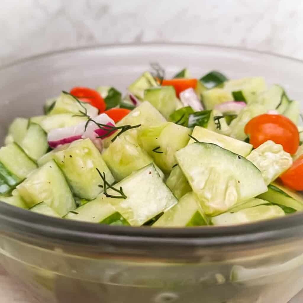 a bowl full of cucumber salad to serve as a side with hamburgers.