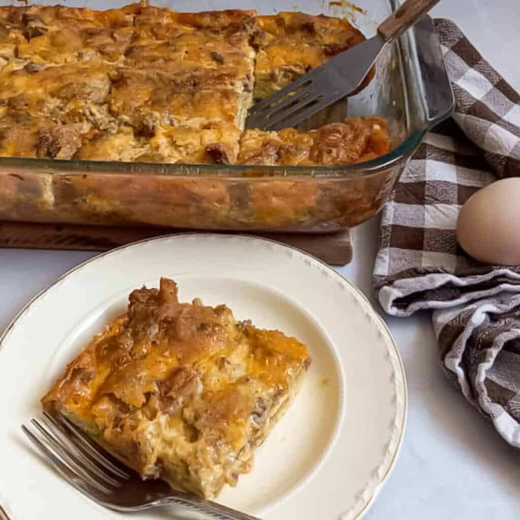 a pan of breakfast casserole made with bread, a slice on a small plate.