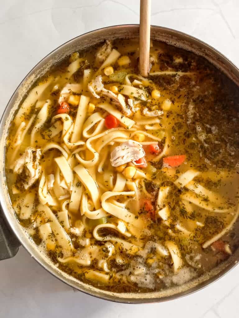 a large pot of chicken corn noodle soup.