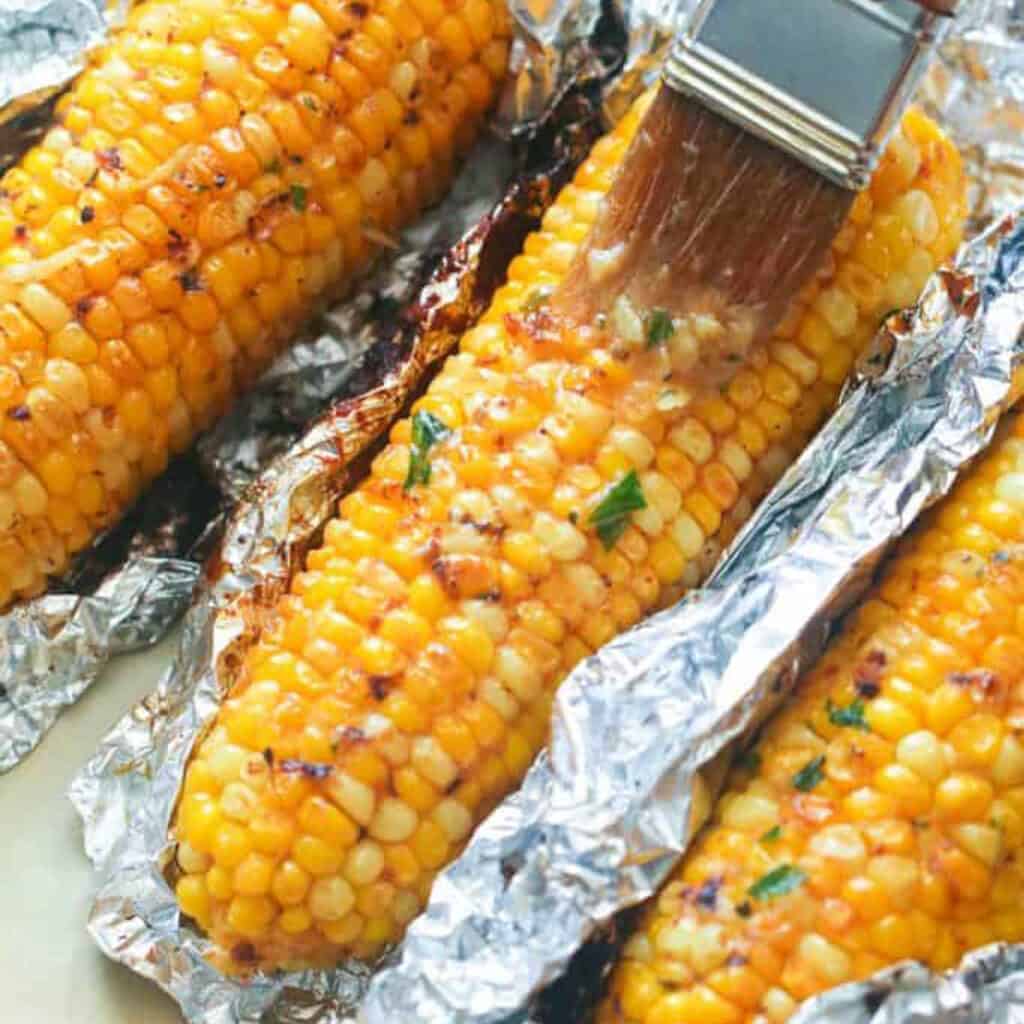 oven-roasted corn cobs brushed with garlic butter.